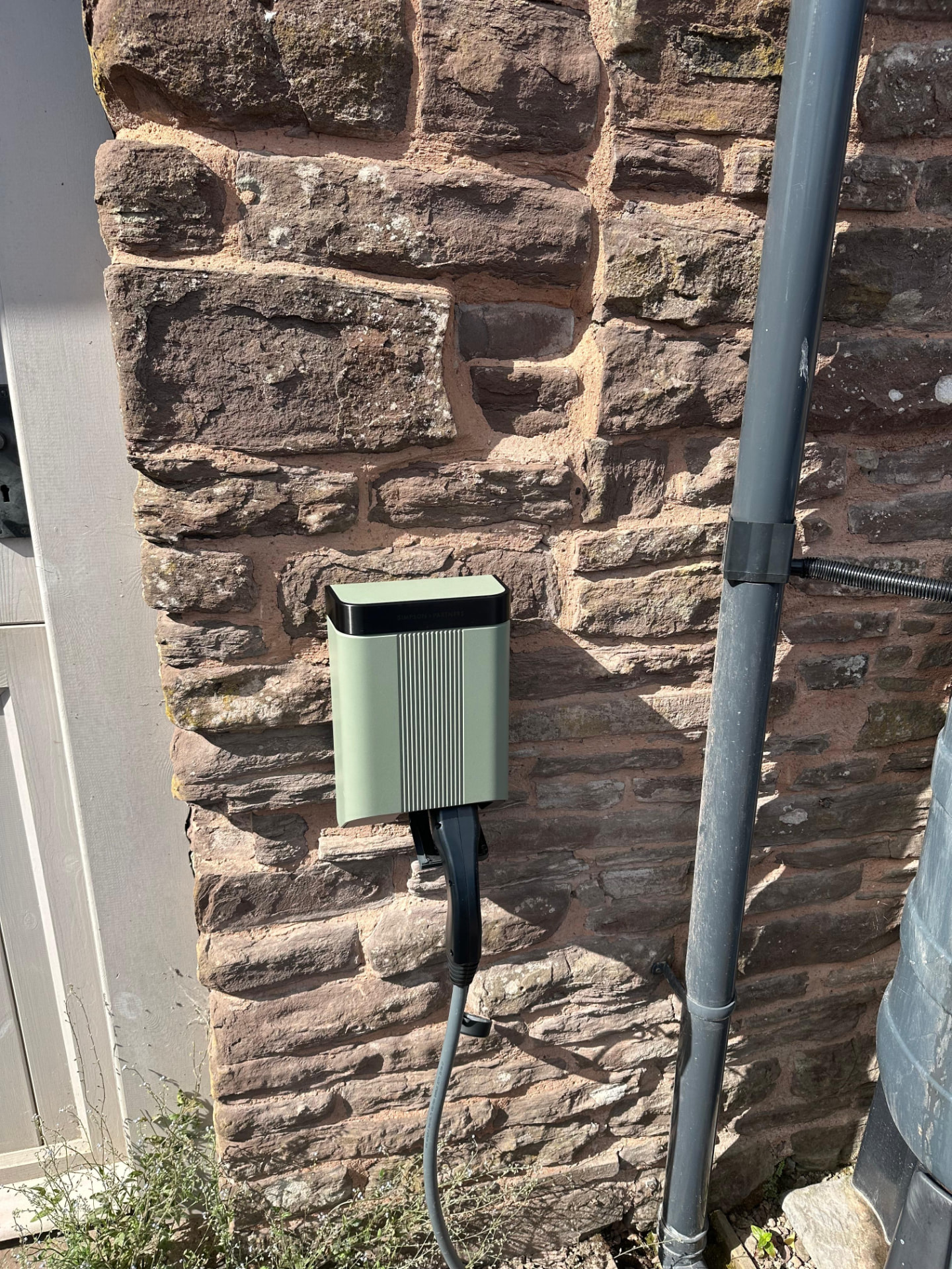 Andersen electric vehicle charging point on a rustic stone exterior wall